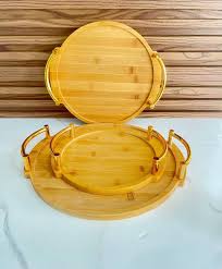 Ensemble de plateaux de service ronds en bambou à plusieurs niveaux avec des poignées dorées.