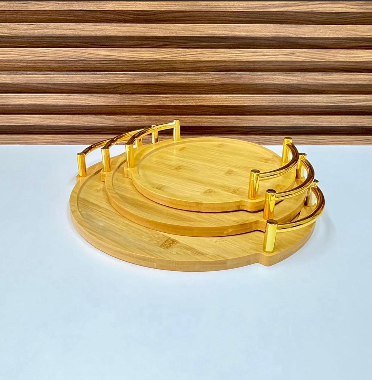 Ensemble de plateaux de service ronds en bambou à plusieurs niveaux avec des poignées dorées.